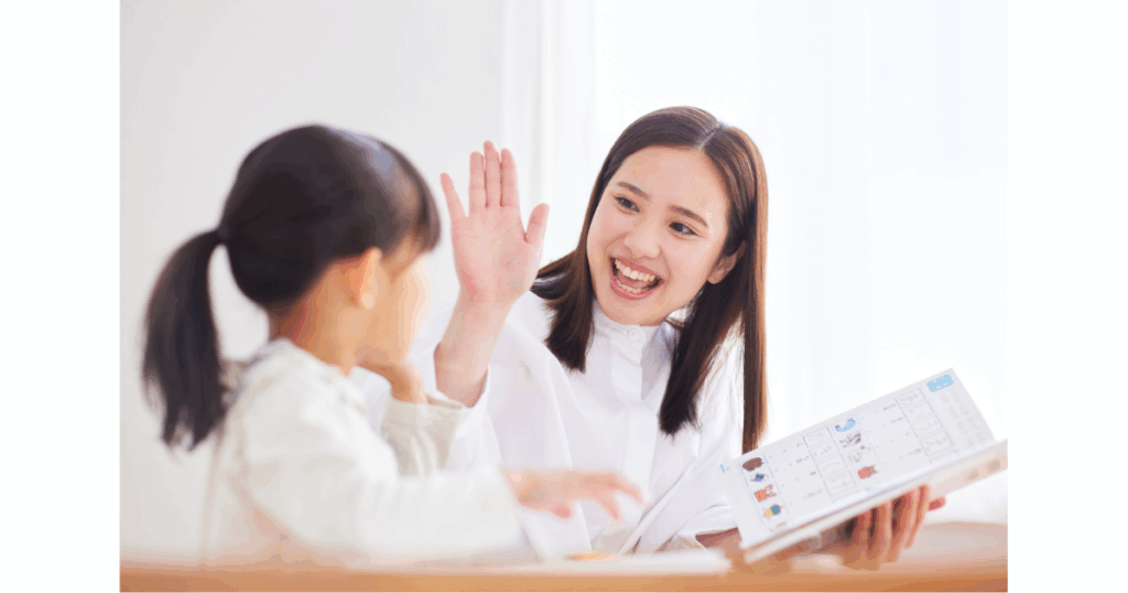 ベビーシッターとハイタッチする子ども