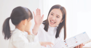 ベビーシッターとハイタッチする子ども